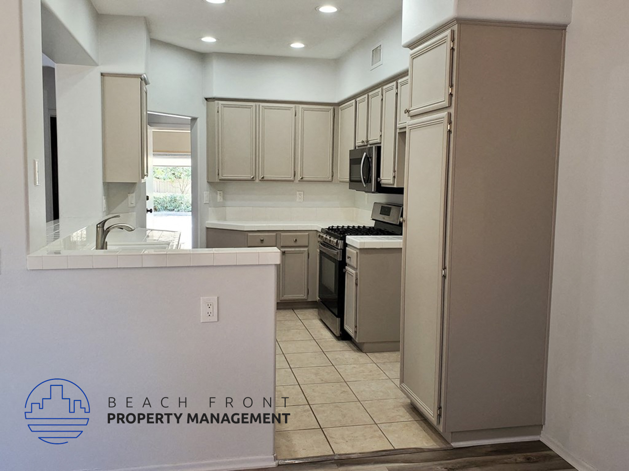 A kitchen with a logo that says Beach Front Property Management.
